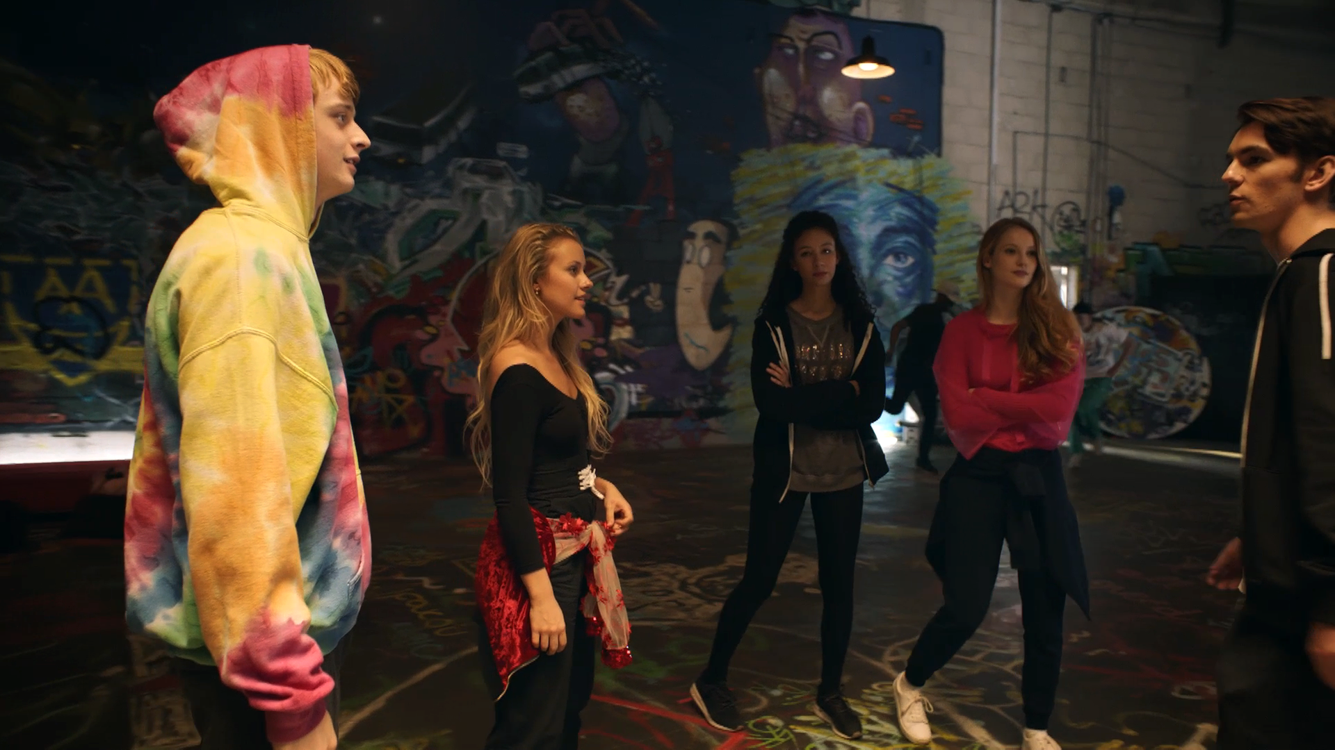 Lena und ihre Freunde stehen in einer alten Fabrik in einem Kreis