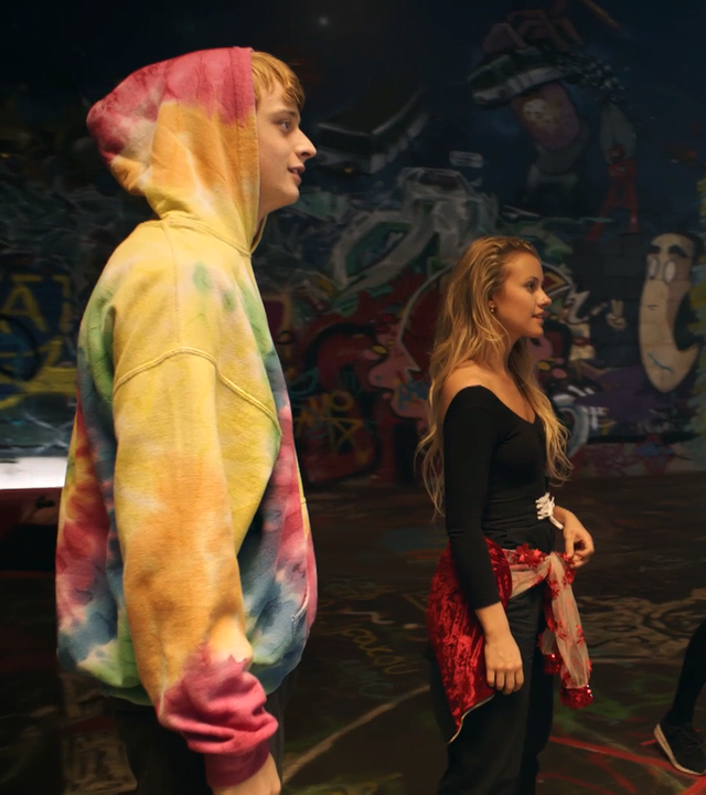 Lena und ihre Freunde stehen in einer alten Fabrik in einem Kreis