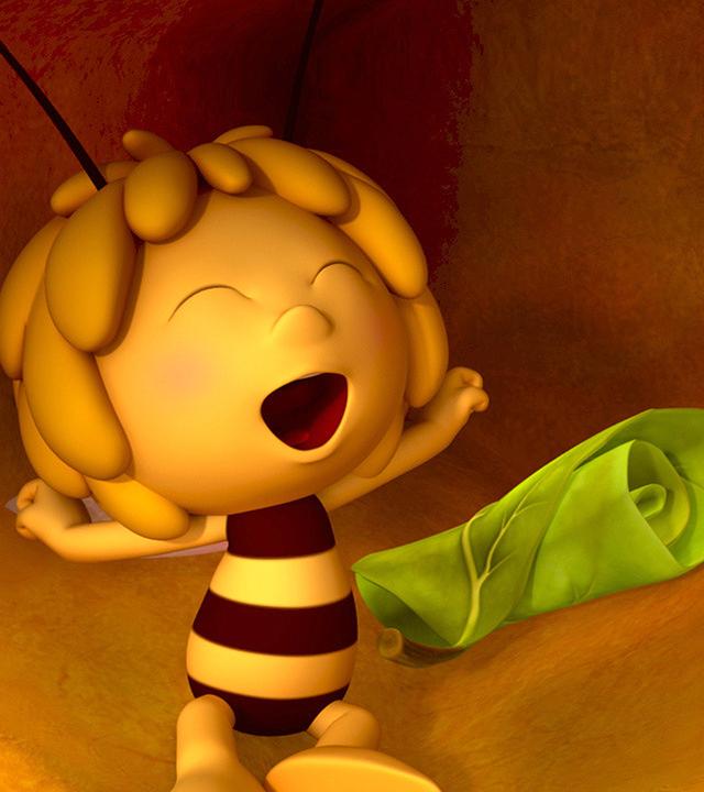 Biene Maja streckt gähnend ihre Arme aus. Hinter ihr ist ein zusammengerolltes Blatt zu sehen.