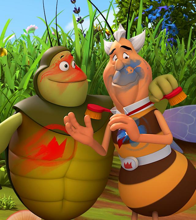 Richter Bienenwachs und Kurt stehen Arm in Arm nebeneinander und sind mit Farbe beschmiert.