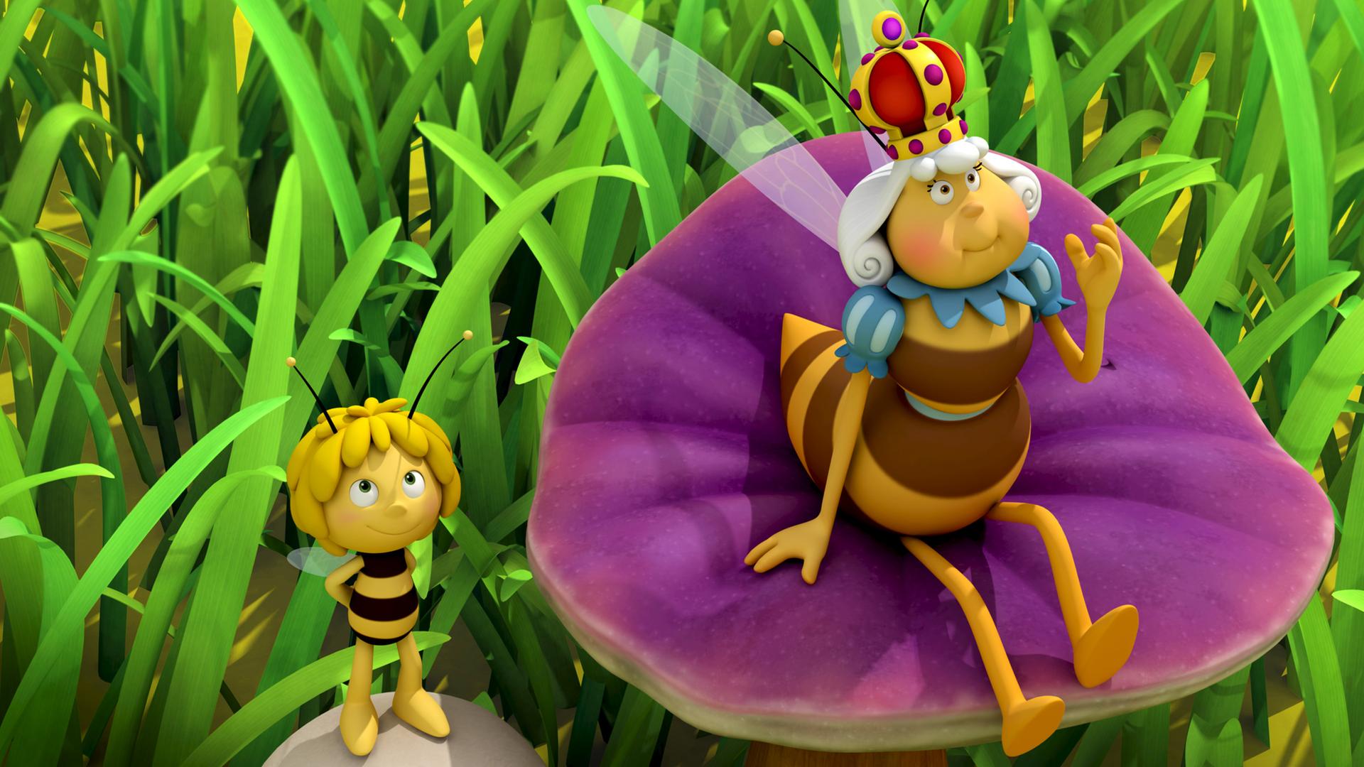 Die Bienenkönigin hat den Bienenstock verlassen und sitzt nun entspannt auf einer Blume auf der Wiese. Neben ihr steht Maja auf einem Stein.