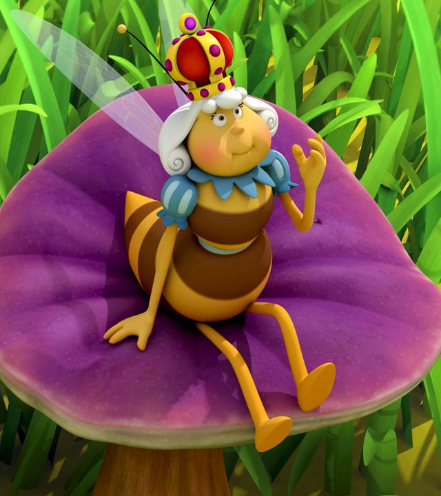 Die Bienenkönigin hat den Bienenstock verlassen und sitzt nun entspannt auf einer Blume auf der Wiese. Neben ihr steht Maja auf einem Stein.
