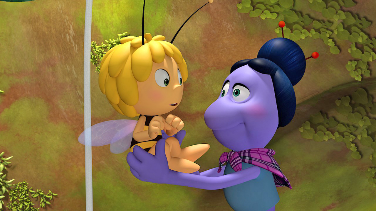 Spinne Thekla hält Maja vor sich und die beiden schauen sich an. Maja schaut etwas erschrocken.