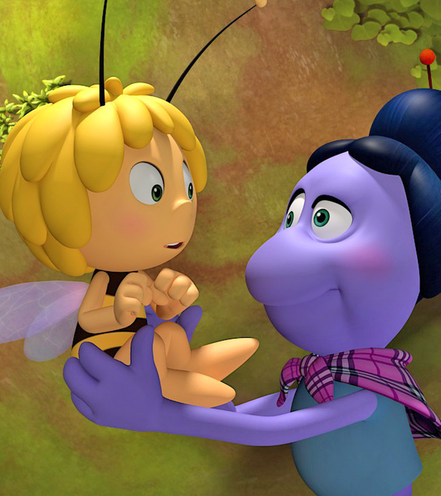 Spinne Thekla hält Maja vor sich und die beiden schauen sich an. Maja schaut etwas erschrocken.