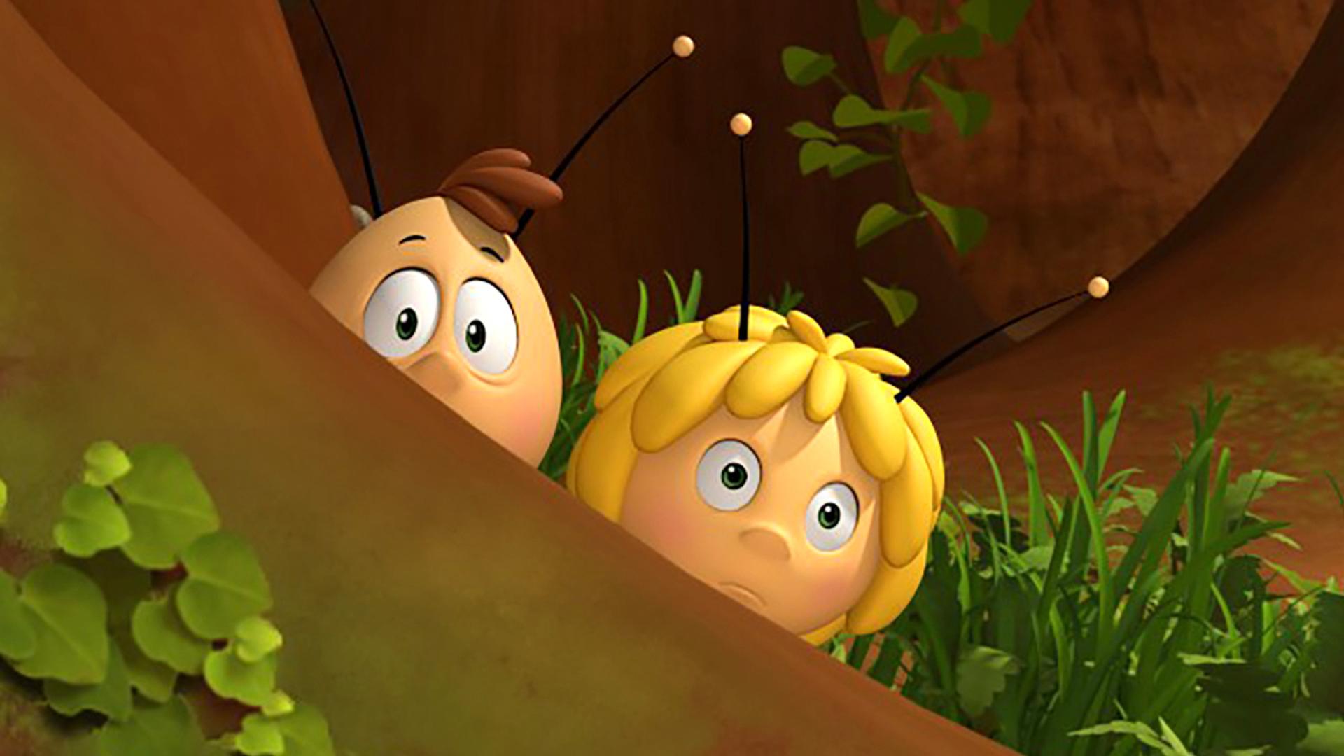 Willi und Maja verstecken sich hinter einem Baum und beobachten etwas.