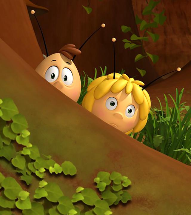 Willi und Maja verstecken sich hinter einem Baum und beobachten etwas.