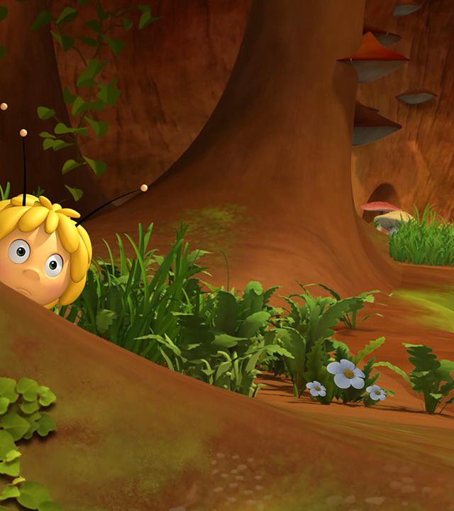 Willi und Maja verstecken sich hinter einem Baum und beobachten etwas.