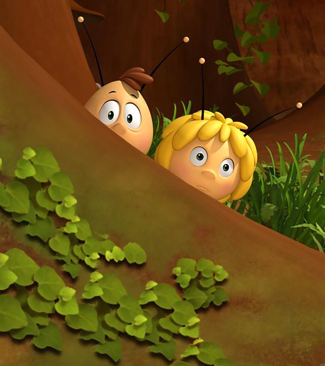 Willi und Maja verstecken sich hinter einem Baum und beobachten etwas.