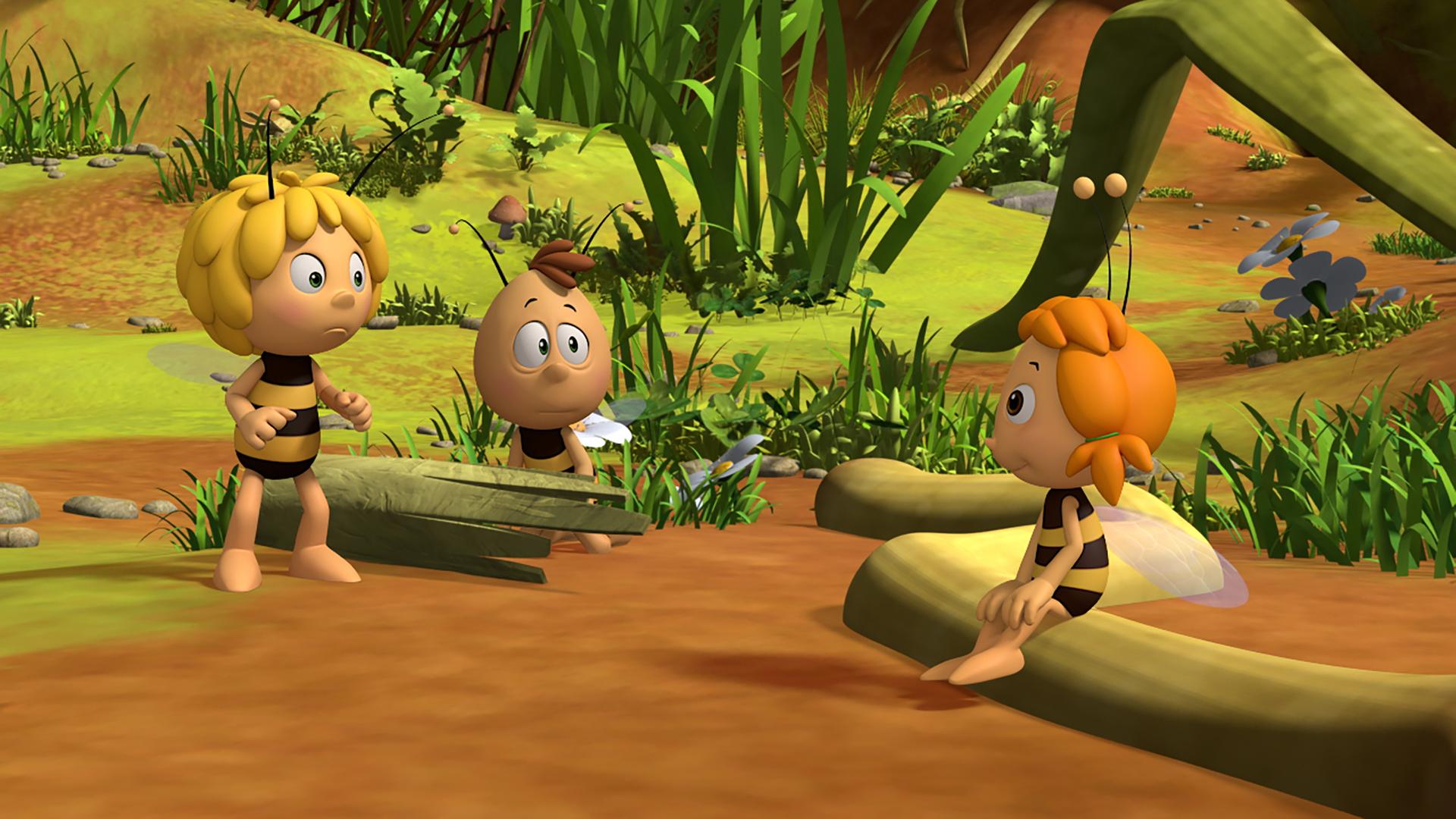 Maja und Willi zeigen einem Bienenschüler die Wiese. Dieser sitzt auf einem Baumstamm.