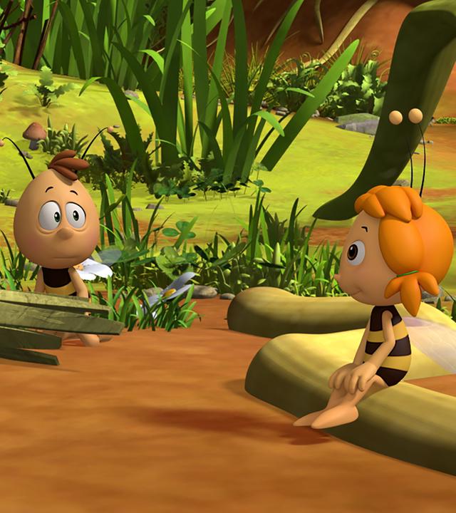 Maja und Willi zeigen einem Bienenschüler die Wiese. Dieser sitzt auf einem Baumstamm.