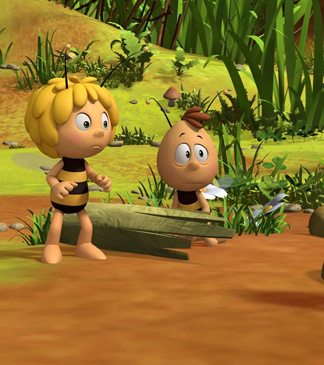 Maja und Willi zeigen einem Bienenschüler die Wiese. Dieser sitzt auf einem Baumstamm.