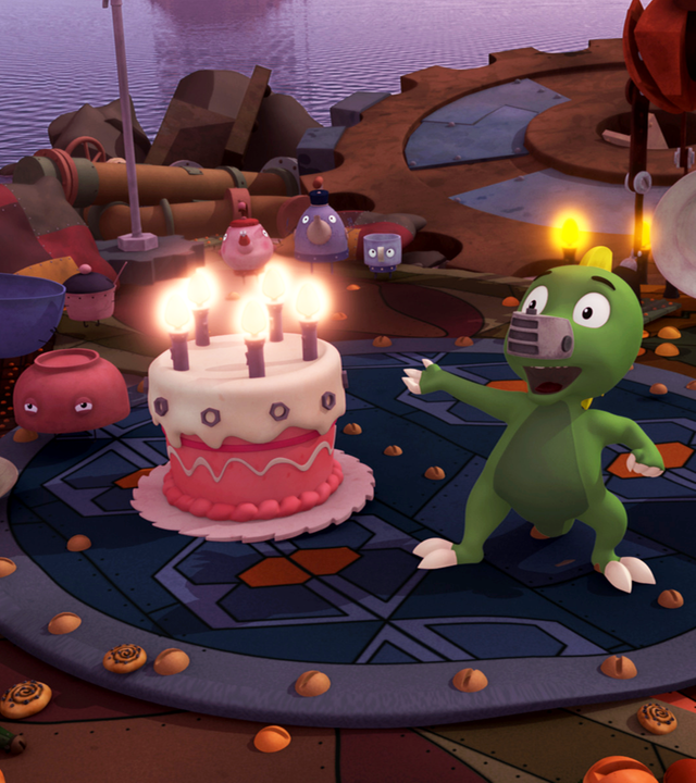 Koks steht neben einer Geburtstagstorte mit Kerzen. 