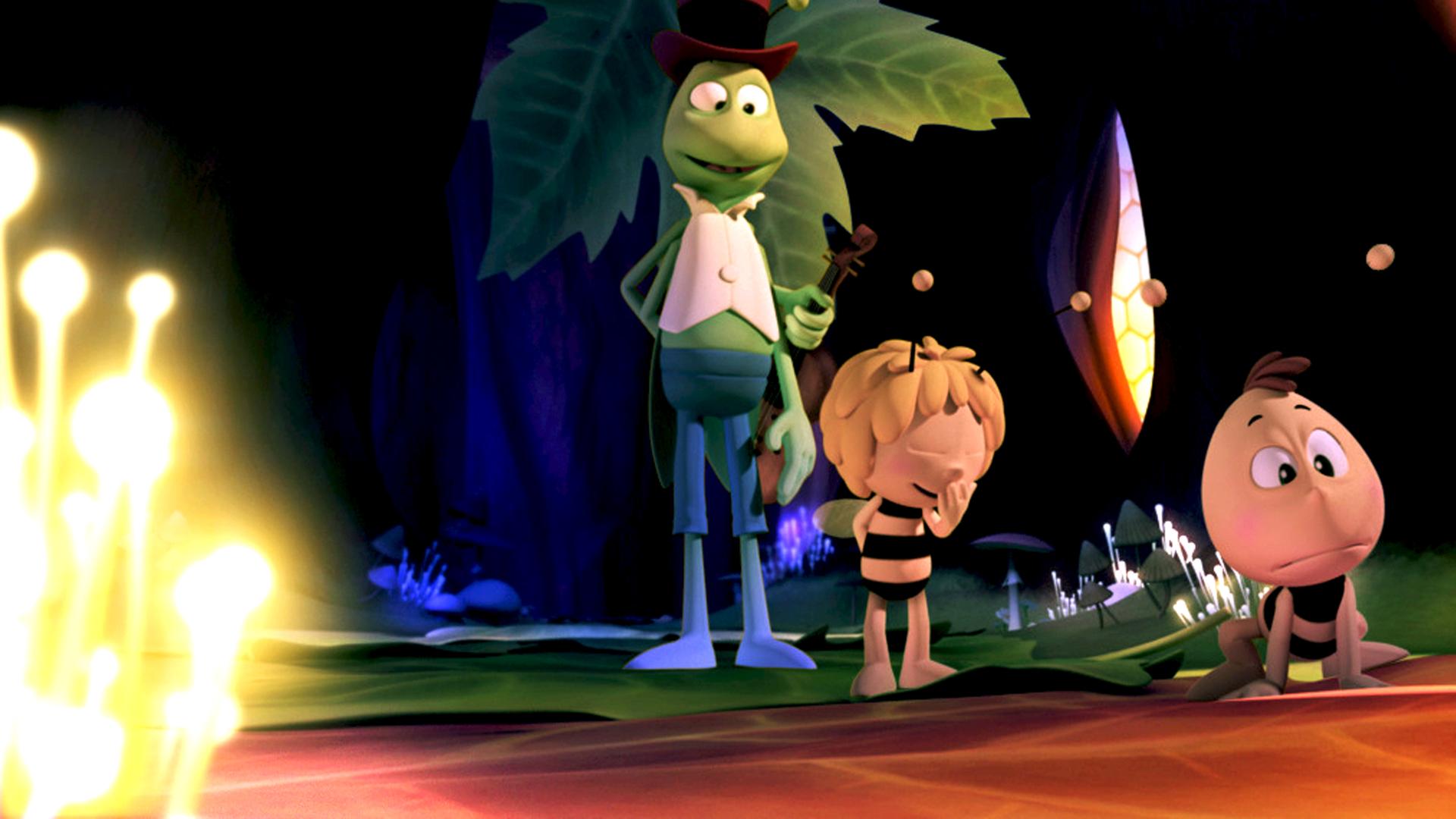 Willi, Maja und Flip bei Nacht im Bienenstock. Die Bienenwaben strahlen Licht aus und beleuchten den Platz.