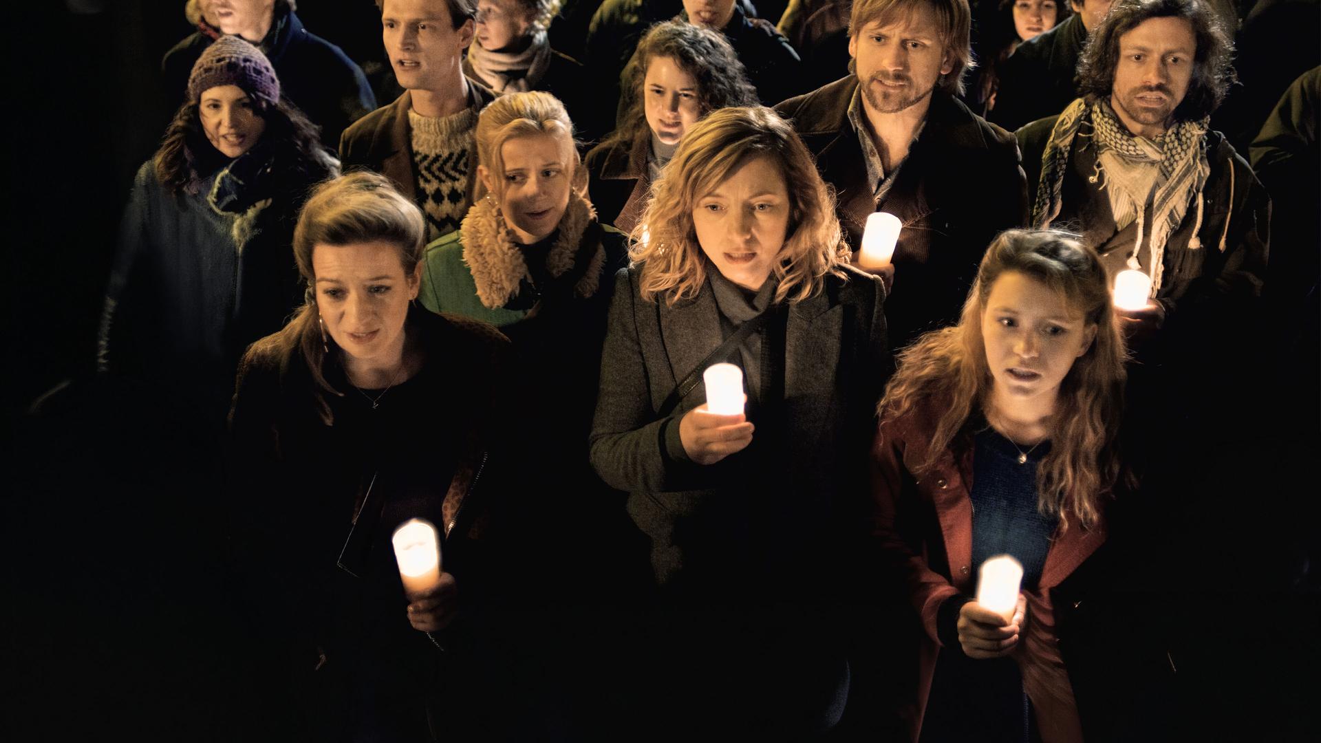 "Preis der Freiheit (2)": Bine (Nina Gummich), Lotte (Nadja Uhl) und Christa (Janina Fautz) sind umgeben von vielen Menschen, die wie sie eine Kerze in der Hand halten.