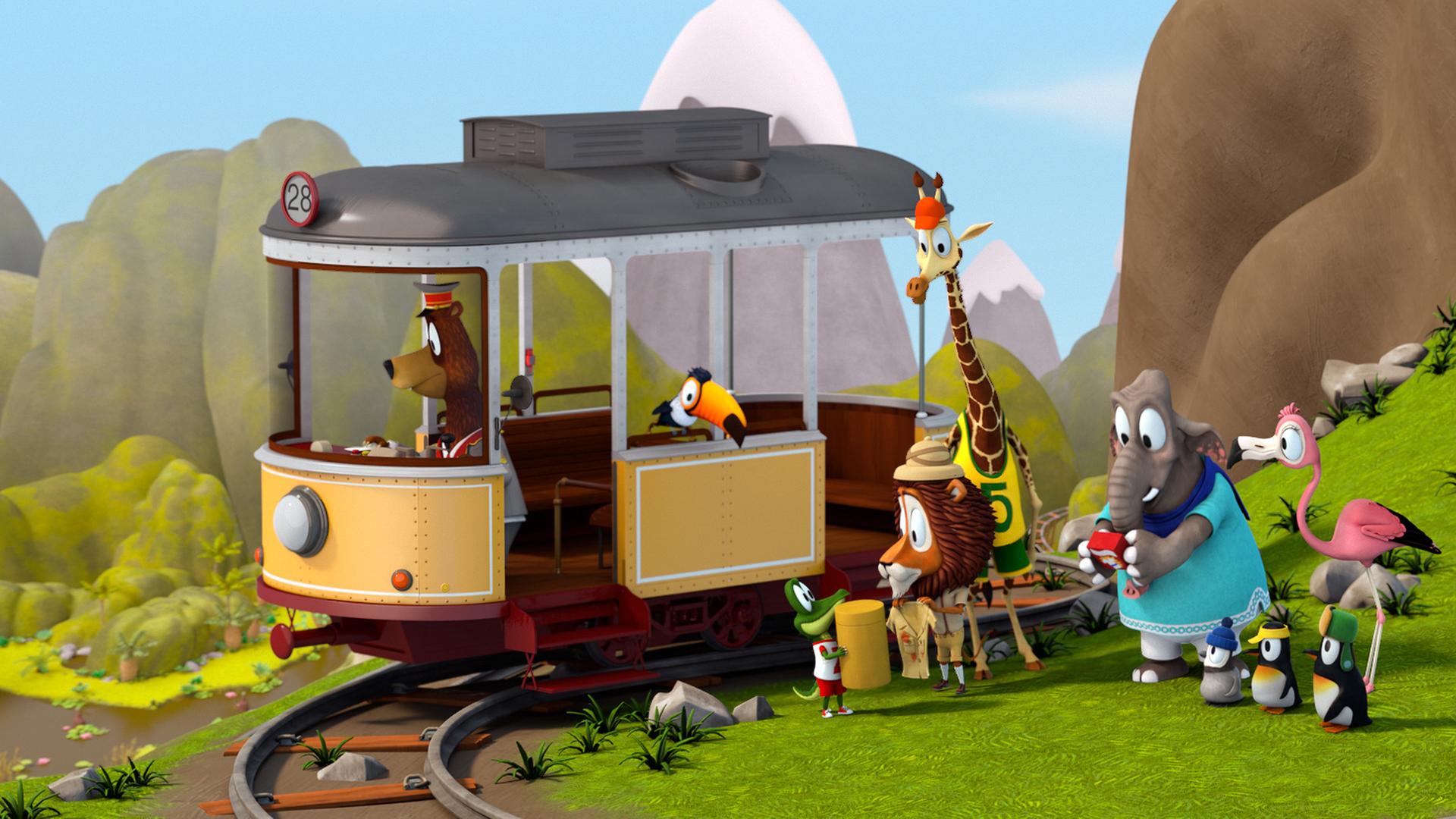 Unterhalb eines Felsens verläuft ein Schienenstrang, darauf steht die Straßenbahn. Am Steuer steht Fahrer Balduin (Bär) und im Fenster hockt Tukan Toni. Die anderen Tiere stehen vor der Bahn.