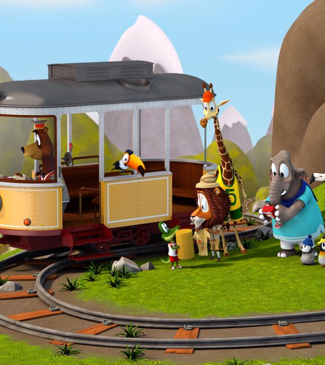 Unterhalb eines Felsens verläuft ein Schienenstrang, darauf steht die Straßenbahn. Am Steuer steht Fahrer Balduin (Bär) und im Fenster hockt Tukan Toni. Die anderen Tiere stehen vor der Bahn.