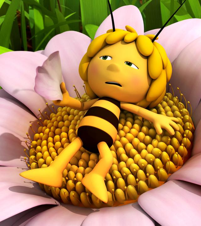 Maja liegt erschöpft und mit ausgestreckten Armen auf einer Blume. Dabei fächelt sie sich mit einer Blüte Luft zu.