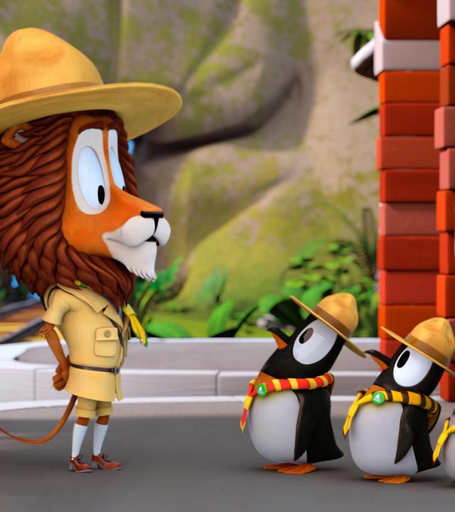 Lionel steht vor den hintereinander aufgereiheten Pinguinen. Zacki beobachtet sie aus der Bahn heraus.