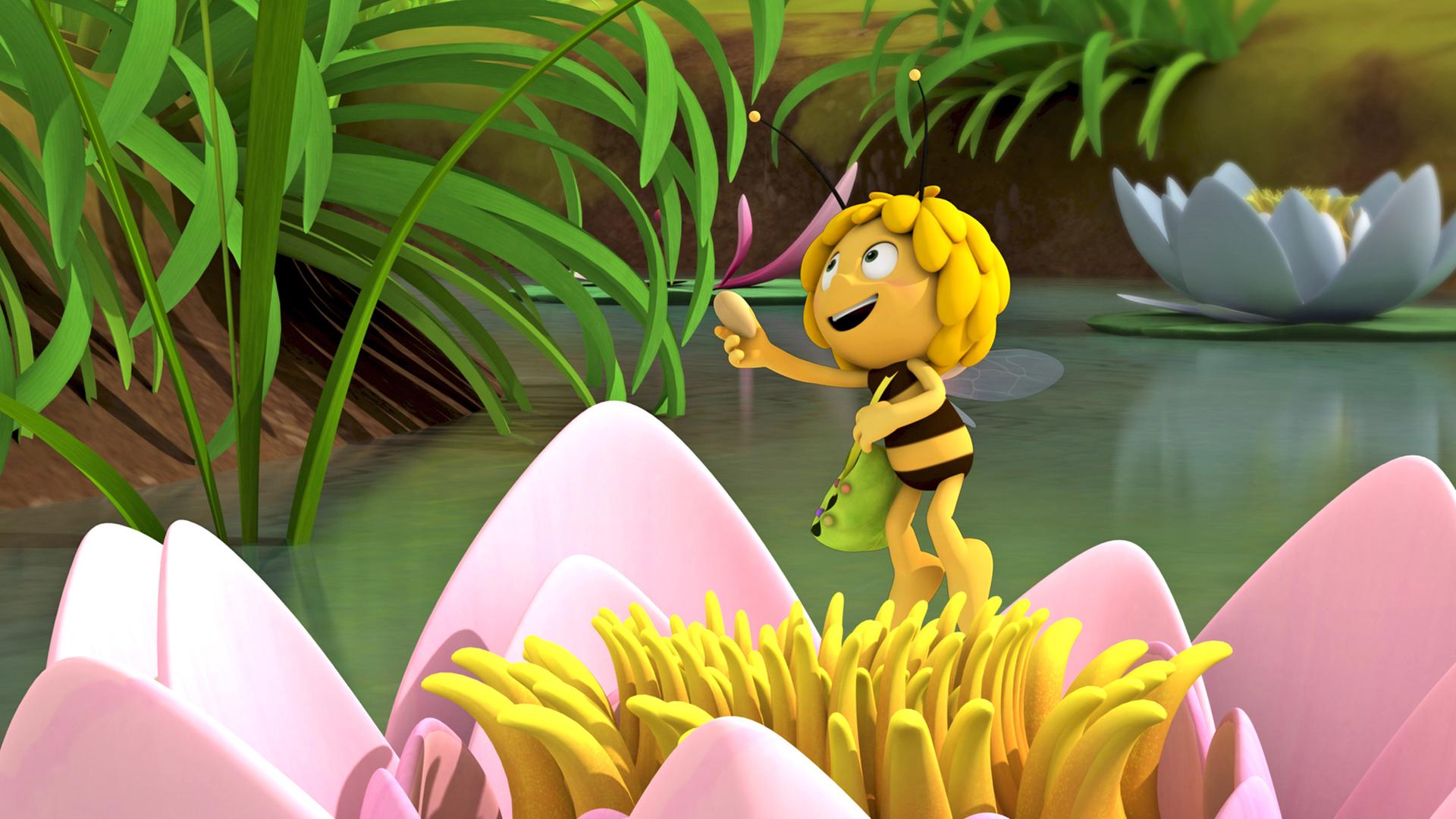 Maja sammelt Blüten einer Seerose für den Kuchen.