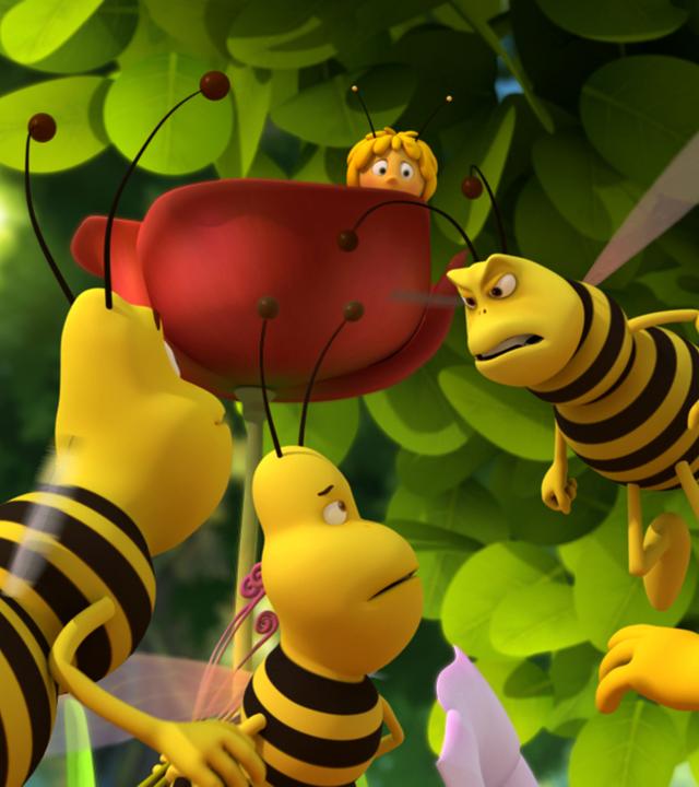 Jesper wehrt sich gegen die Wespenbande. Maja versteckt sich im Hintergrund hinter einer Blume.