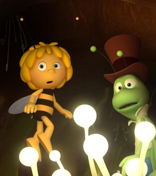 Maja und Flip sind in einem dunklen Erdloch unterwegs. Einzig weiße Lichtpflanzen weisen ihnen den Weg.