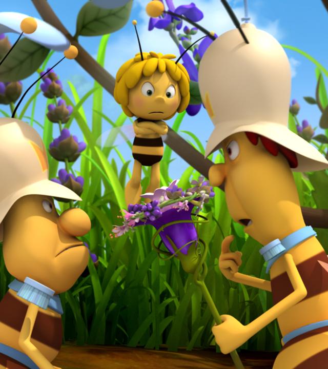 Maja steht mit verschränkten Armen und mit verärgertem Blick vor zwei Bienenpolizisten die sich streiten.