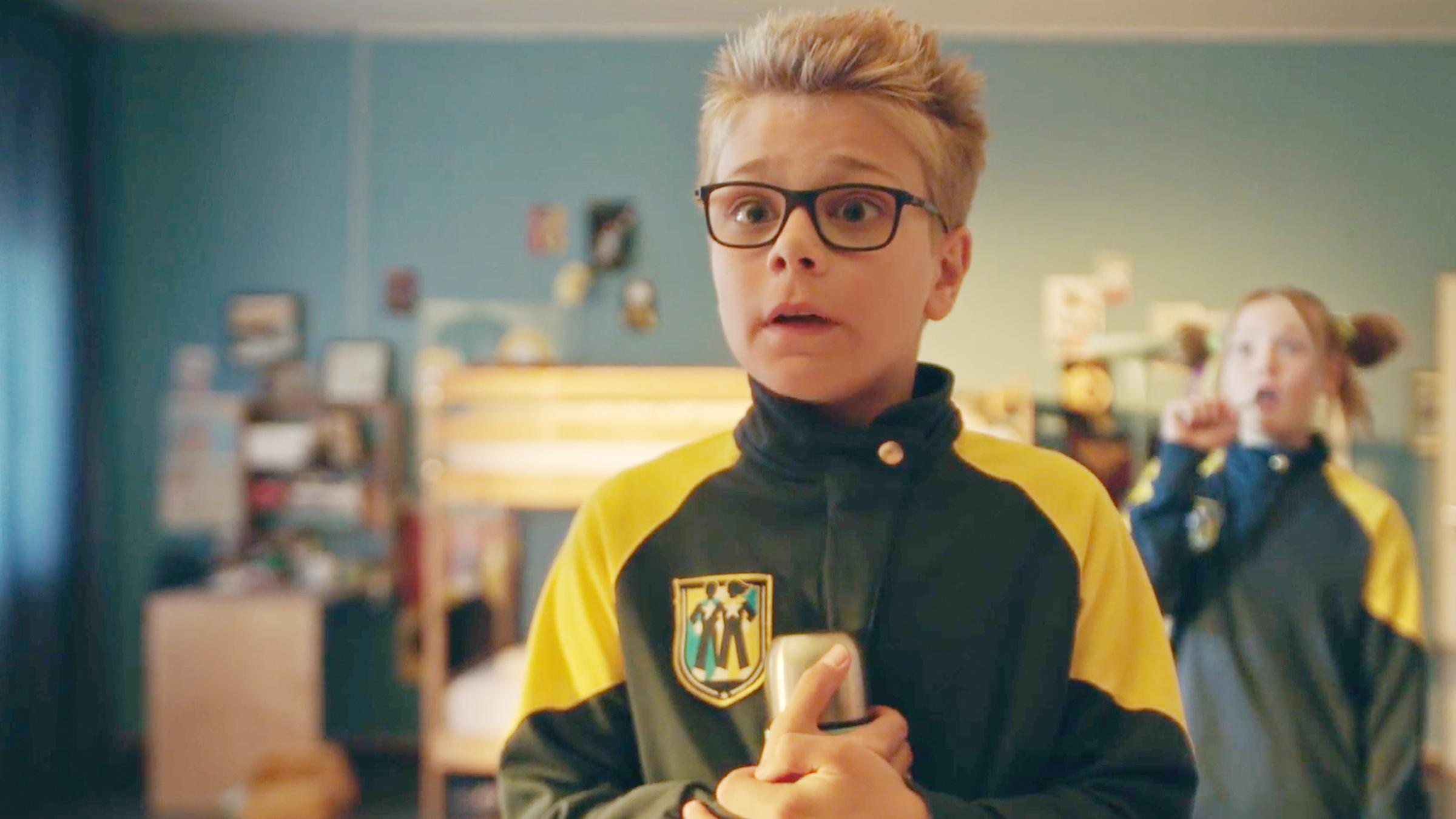 Im Schlafsaal steht Uno mit erschrockenem Blick und einer Trinkflasche in seinen beiden Händen, die er an sich gepresst hat. Hinter ihm steht Tele, die sich gerade mit ihrer rechten Hand die Zähne putzt. Sie schaut mit überraschtem Blick und offenem Mund zu Uno.