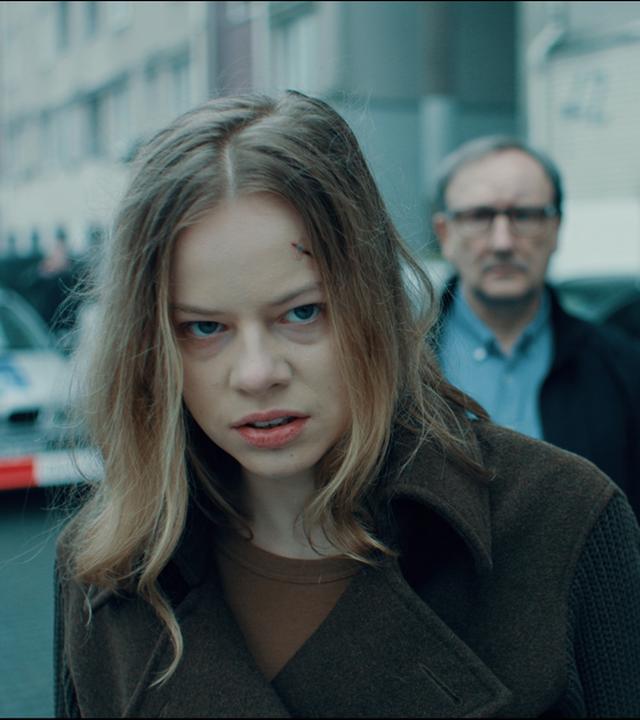 Julia (Emma Bading) steht mit wutverzerrtem Gesicht vor dem Haus ihres toten Vaters