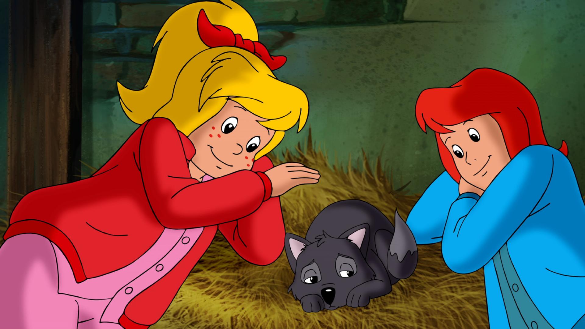 Bibi und Tina liegen auf Heu gebettet, zwischen ihnen liegt ein kleiner zusammengerollter Wolf, der sehr unglücklich aussieht.