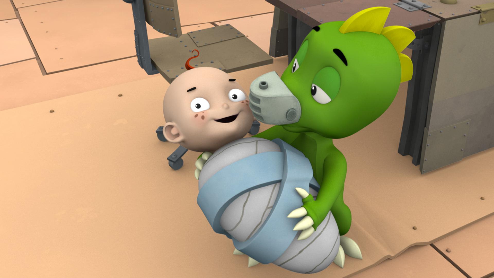 Drache Koks hält das grinsende Baby im Arm.