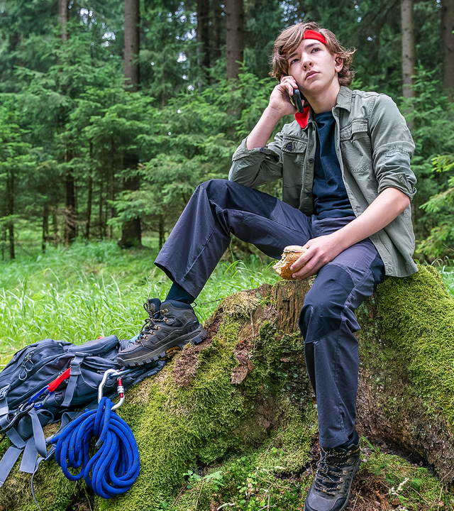 Mitten im Wald sitzt auf einem Baustumpf der siebzehnjährige Rob. Er trägt ein rotes Stirnband, typische Outdoor-Kleidung, zu seinen Füßen liegt ein Rucksack samt Seil und Kletterhaken. Mit selbstgewisser Mine telefoniert er über sein Handy, hält in seiner anderen Hand ein angebissenes Brötchen und scheint den Moment völlig entspannt zu genießen.