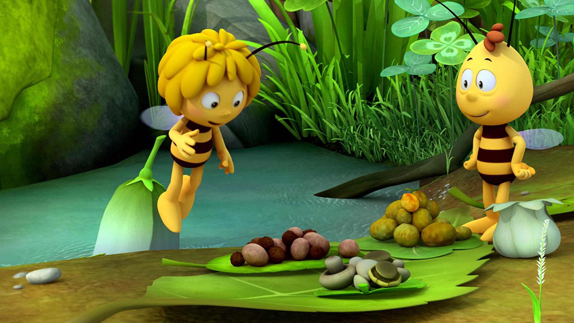 Biene Maja und Willi beim Picknick. Sie starren fröhlich auf ihr Picknick aus Pilzen und Nüssen, das vor ihnen auf Blättern liegt.