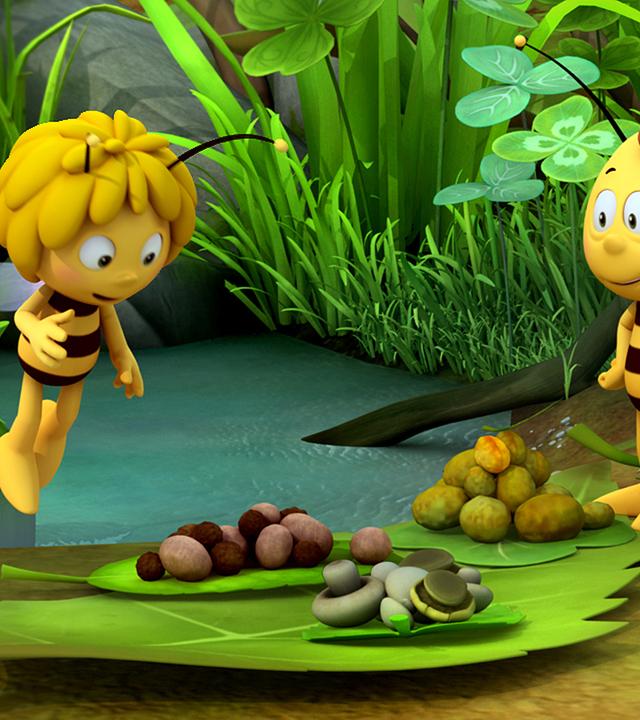 Biene Maja (links) und Willi (rechts) beim Picknick. Sie starren fröhlich auf ihr Picknick aus Pilzen und Nüssen, das vor ihnen auf Blättern liegt.