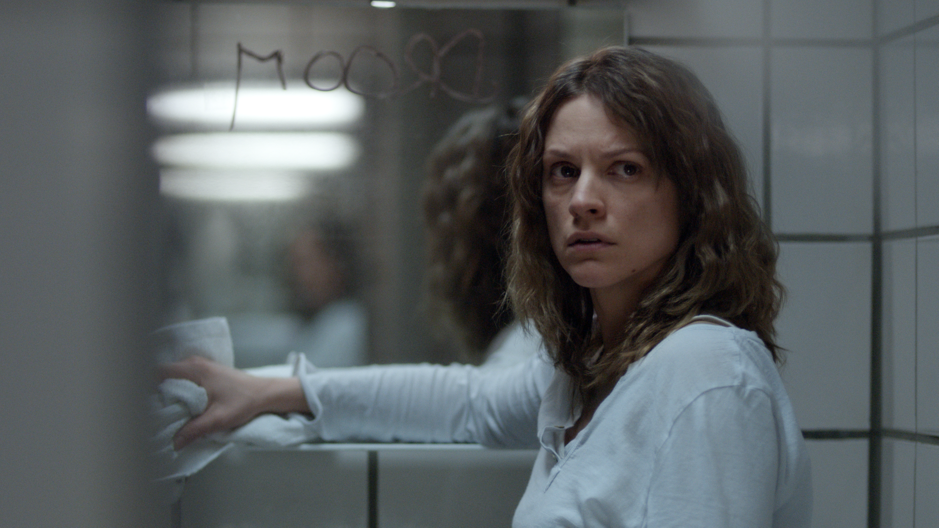 Mie steht beängstigt im Badezimmer am Spiegel