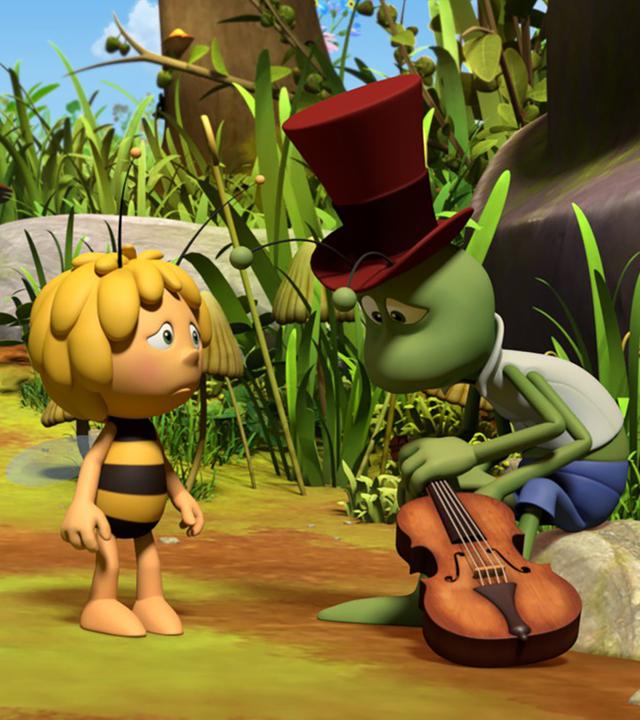 Flip und Maja schauen traurig drein. Flip sitzt niedergeschlagen mit seiner Geige auf einem Stein.