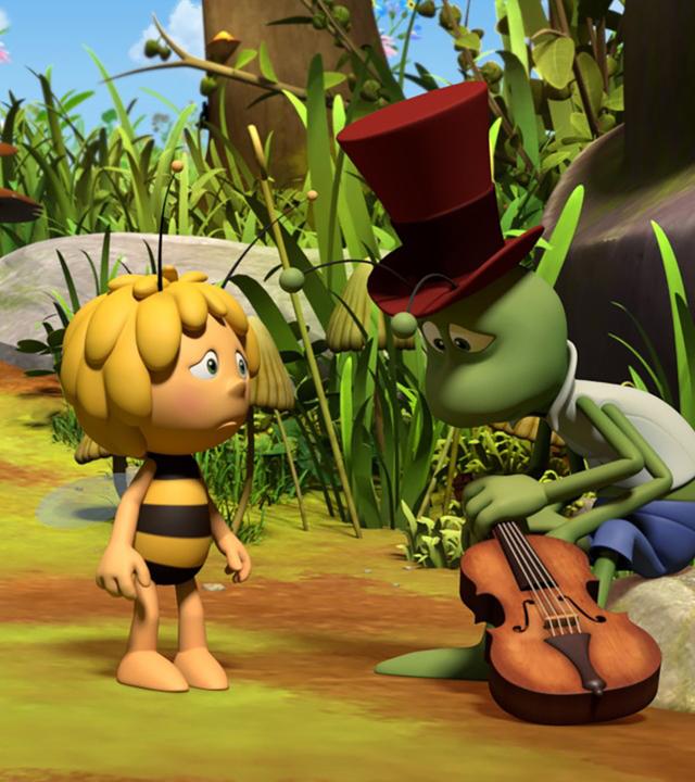 Flip und Maja schauen traurig drein. Flip sitzt niedergeschlagen mit seiner Geige auf einem Stein.