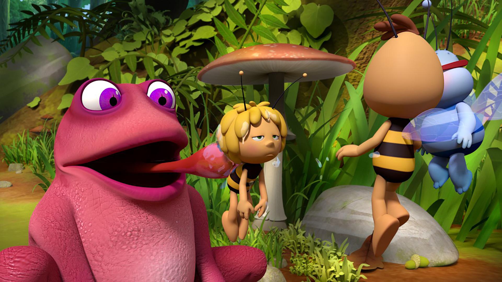 Kröte Rosalie schlabbert Biene Maja mit der Zunge ab. Willi und Walter fliegen vor Maja.