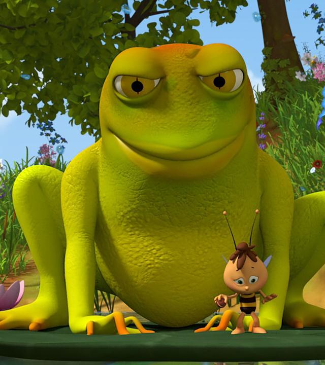 Willi steht auf einer Seerose. Hinter ihm lauert ein sehr großer Frosch.