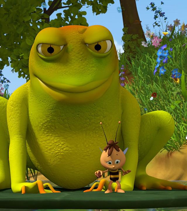 Willi steht auf einer Seerose. Hinter ihm lauert ein sehr großer Frosch.