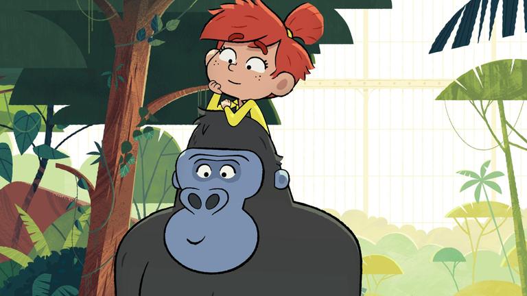 Das rothaarige Mädchen Taylor sitzt lächelnd auf den Schultern eines freundlich dreinblickenden Gorillas. Er trägt sie durch den Dschungel.