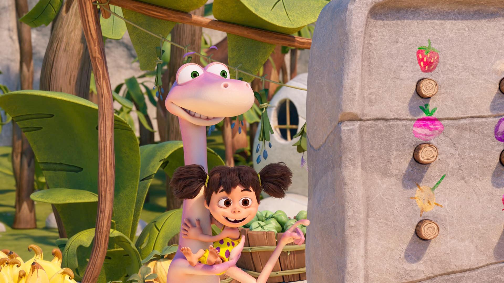 Der rosafarbene Dinosaurier Minus Drei hält seine Freundin, das Menschenmädchen Lucy, im Arm. Er zeigt auf eine steinzeitliche Maschine mit Holzknöpfen.