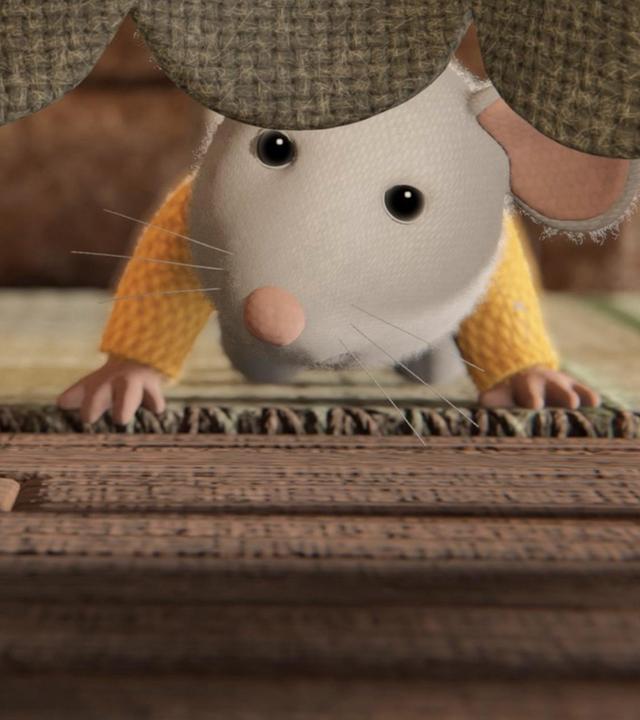 Sam liegt bäuchlings unter einem Tisch und schaut zu Ben, der unter dem herunterhängenden Tischtuch zu Sam durchlugt. Auf dem Boden liegt ein Teppich.