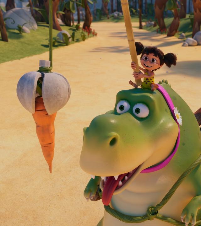 Auf dem Kopf eines großen, grünen Tyrannosaurus Rex sitzt das kleine Steinzeitmädchen Lucy und hält mit einer Art Angel dem großen Tyrannosaurus Rex eine Karotte vor die Nase. Der Tyrannosaurus Rex ist eingespannt - hinter sich her zieht er einen Wagen mit einer Achse, auf dem mit dem Rücken zu uns Herr Fussel und Minus Drei sitzen. Sie fahren auf einer sandigen Straße in Farnheim.