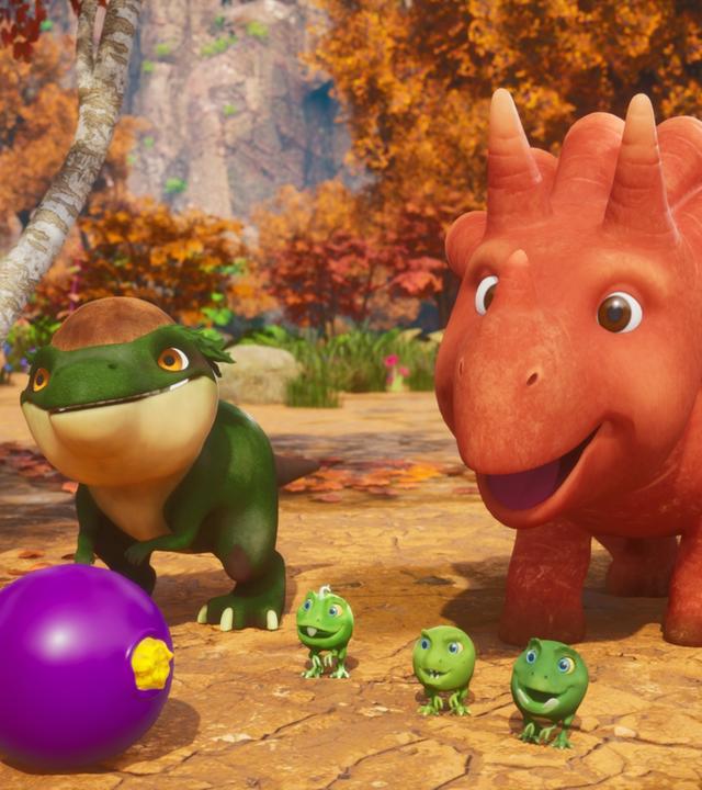 Das Trikarottops-Mädchen Ginger, ihre drei Erbs-Rex-Freunde und ein Avocadodon rennen einer lilafarbenen Beere hinterher. Im Hintergrund ist ein Wald zu sehen.