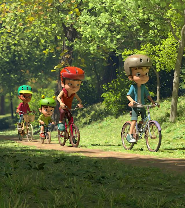 Lina, Kleiner Fuß, Bohnenstange und Raphael sind an einem sonnigen Tag auf einem Waldweg mit ihren Fahrrädern unterwegs. Alle Kinder tragen Fahrradhelme.