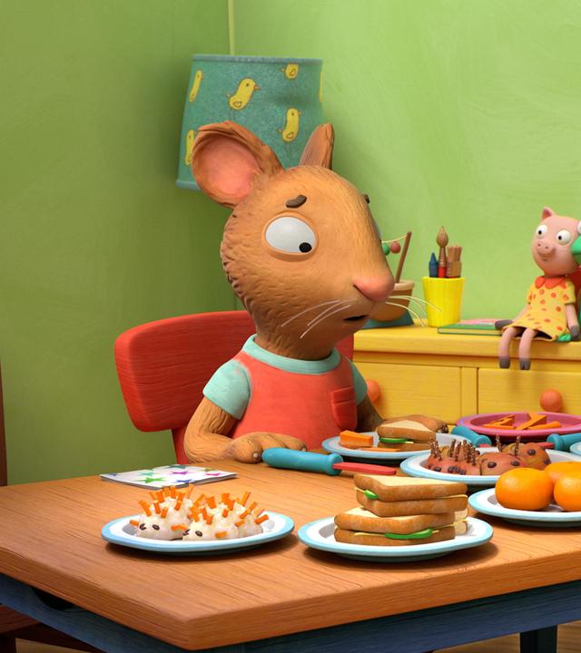 An einem reichlich gedeckten Tisch mit allerlei schön dekorierten Leckereien sitzen die zwei Freunde Posy, die Maus und Pip, das Kaninchen. Posy blickt mit traurigem Blick auf ihren gefüllten Teller. Pip blickt verwundert zu Posy.