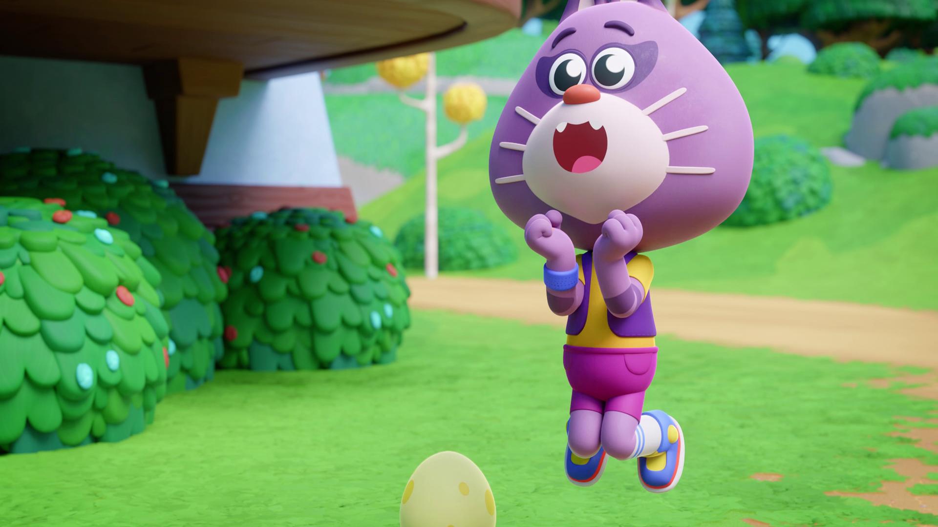 Wir sehen die hüpfende Katze Holly in der Bildmitte einen Freuden-Sprung machen. Holly ist lilafarben, sie trägt bunte Kleidung und macht ein freudiges Gesicht. Links vor ihr steht ein gelbes Ei - das ist ihr Freund Sascha. Im Hintergrund sehen wir Büsche und eine Wiese.