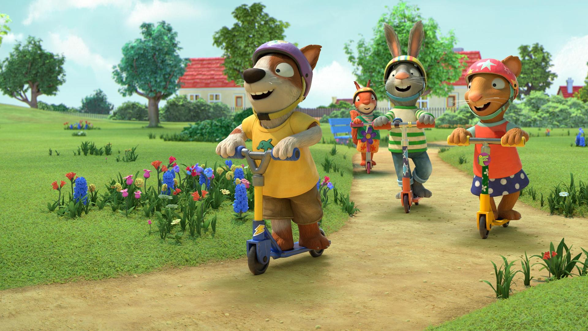 Draußen auf einem Weg im Park findet ein Rollerwettrennen statt. Ganz klar in Führung vorne liegt Zac, der Hund. Hinter ihm folgen Posy die Maus, Pip das Kaninchen und Jamila das Eichhörnchen. Alle lachen und tragen zum Schutz bunte Helme.