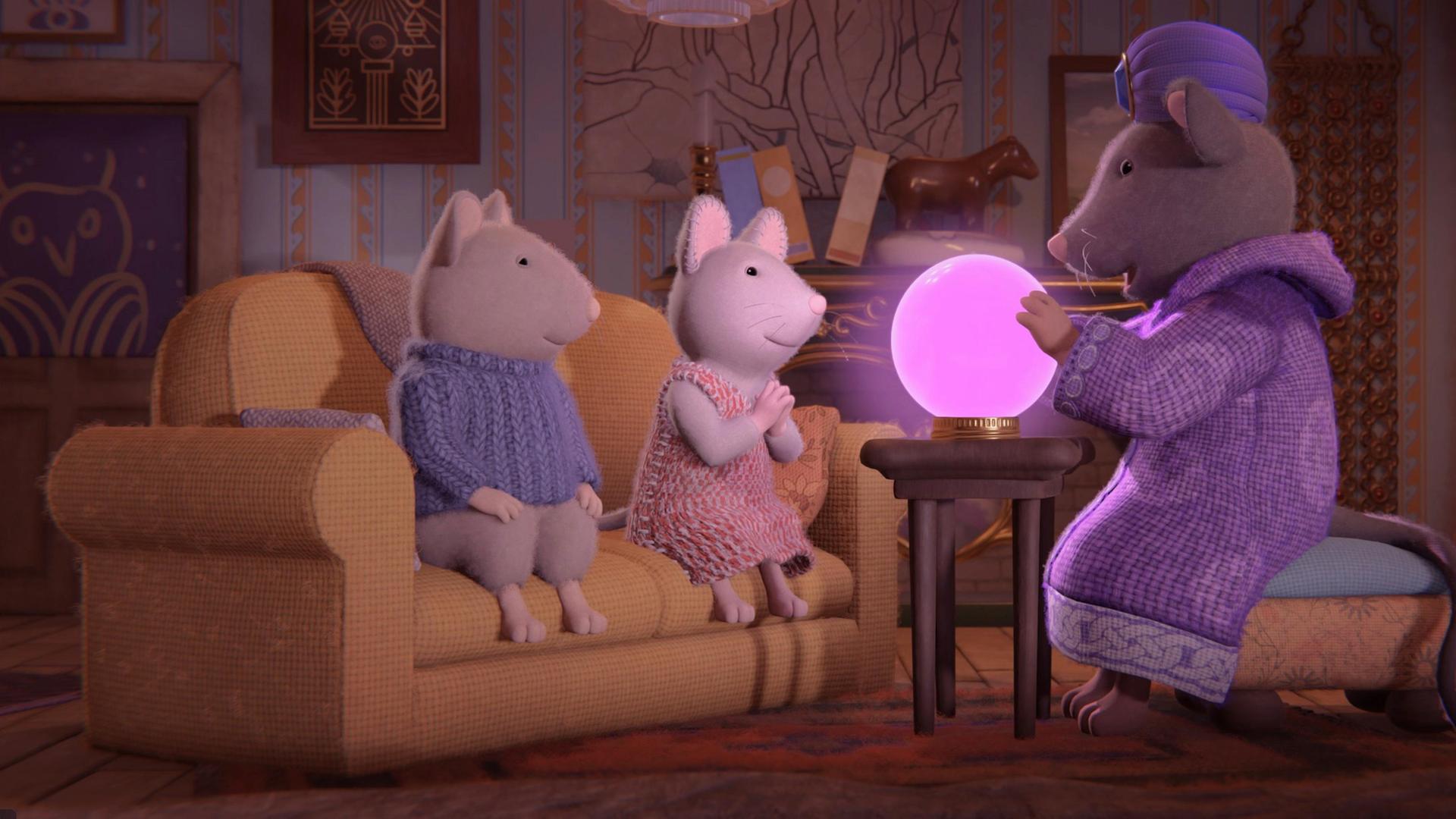 Sam und Julia sitzen auf einem Sofa im Wohnzimmer von Frau Träumer. Frau Träumer sitzt auf einem Hocker und hat eine rosa leuchtende Kugel auf einem kleinen Tisch vor sich stehen. Sie schaut aufmerksam hinein.