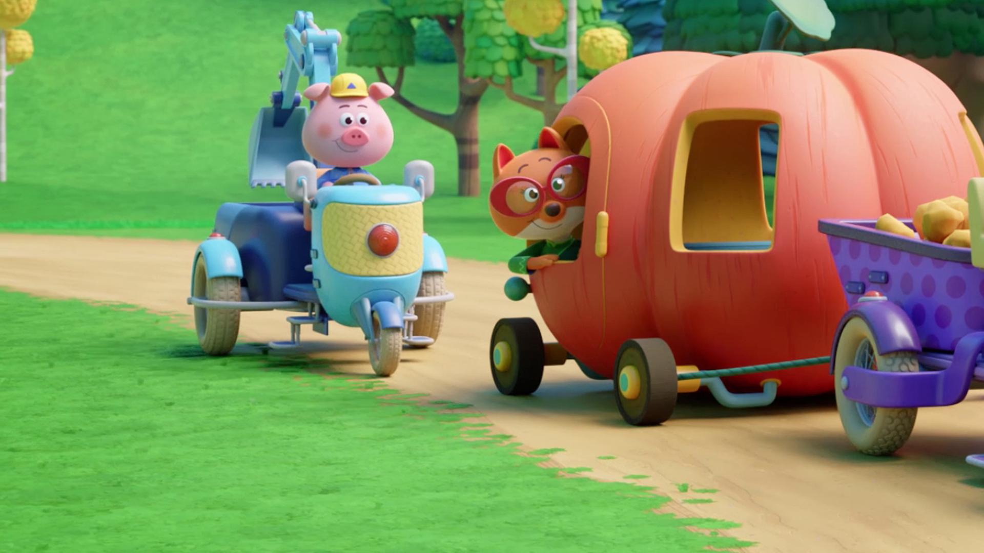 Die Füchsin Fiona sitzt in einem riesigen Kürbis, in den Fenster und eine Tür geschnitzt sind und an dem wie bei einem Auto unten Räder angebracht sind. Sie schaut aus der Fensteröffnung der Tür hinaus. Der Kürbis wird von einer Baumaschine gezogen, die von Schweinchen Cornelia gelenkt wird. Hinter dem Kürbis fährt Schweinchen Charlie auf einer weiteren Baumaschine mit, im rechten Hintergrund lenkt Schweinchen Caesar einen fahrbaren Bagger.